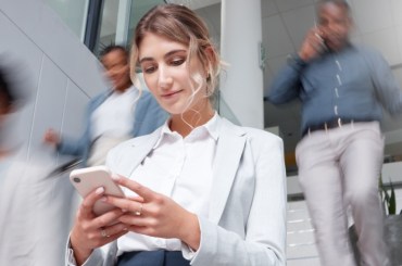 Woman checking her phone while going down stairs