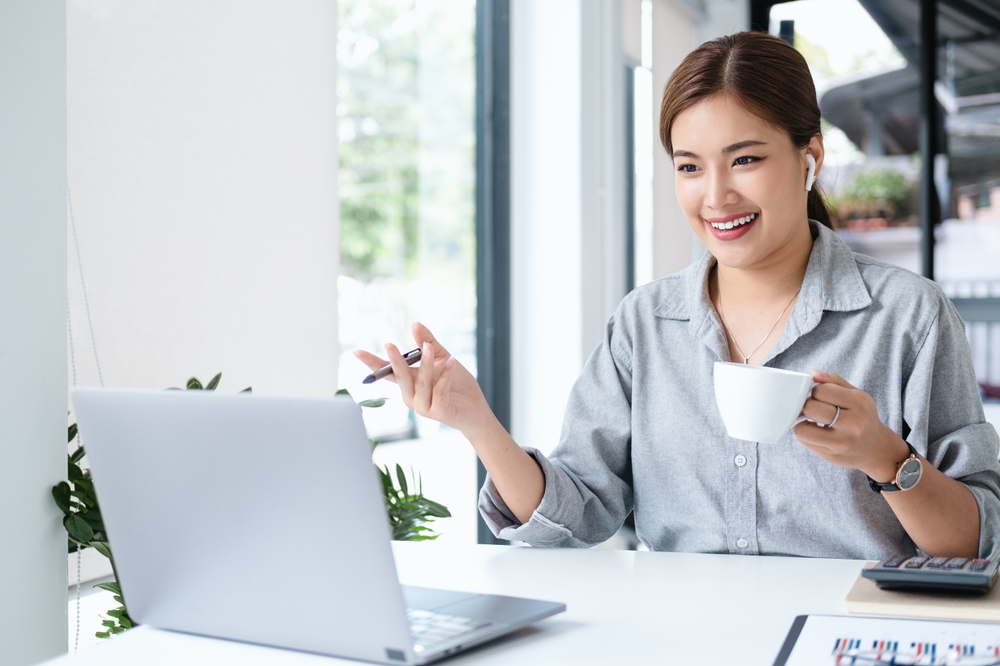 Video conference remote call. Business internet telework. Businesswoman drinking coffee by laptop.