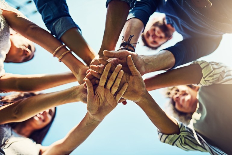 Hands, low angle and pile for team building with friends outdoor, support and solidarity in nature. Community, mission and partnership, trust and commitment with loyalty, group huddle and agreement