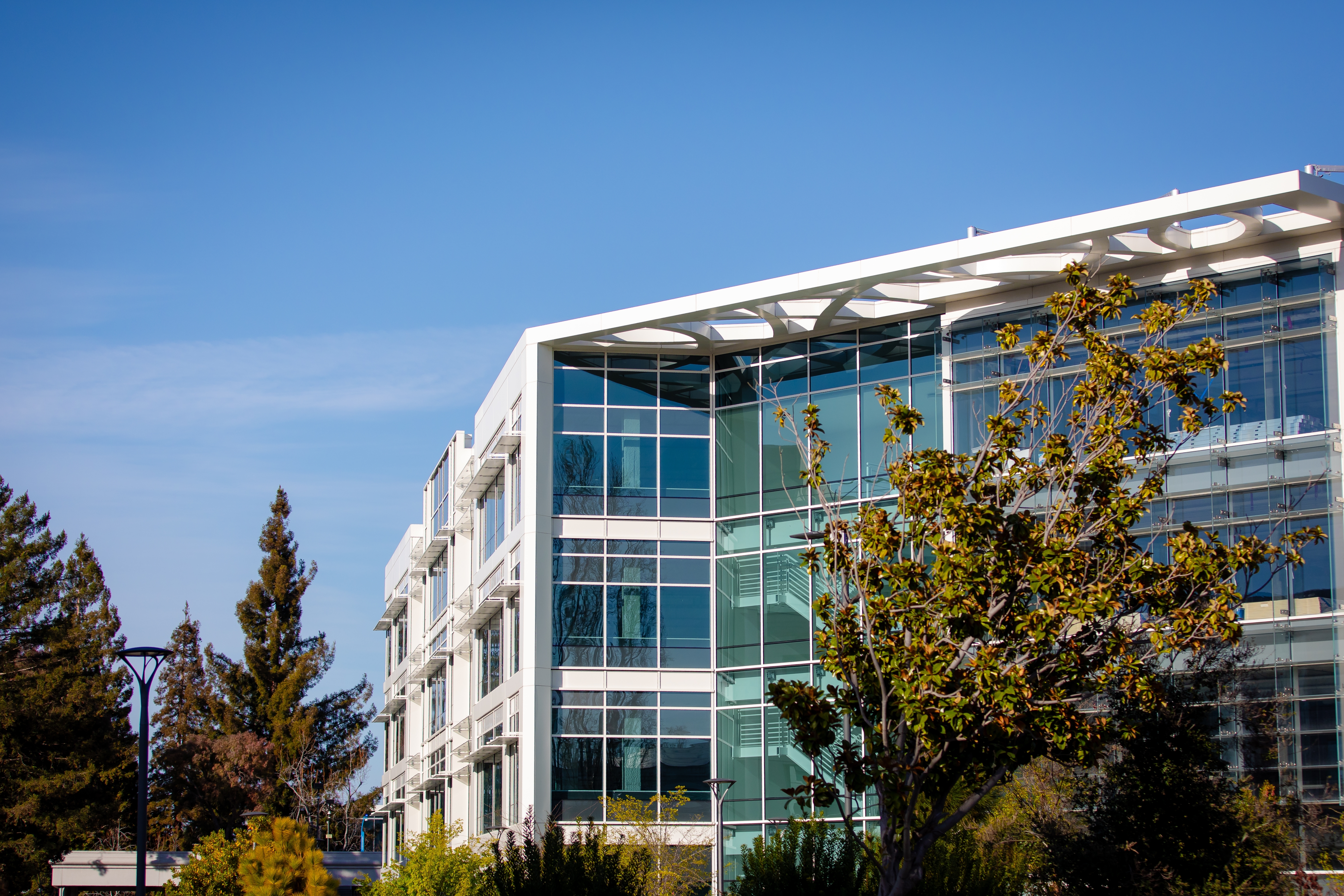 TailoredSpace Kicks Off 2026 Expansion With 16th Coworking Campus in Orange, CA glass office building with a few trees surrounding it