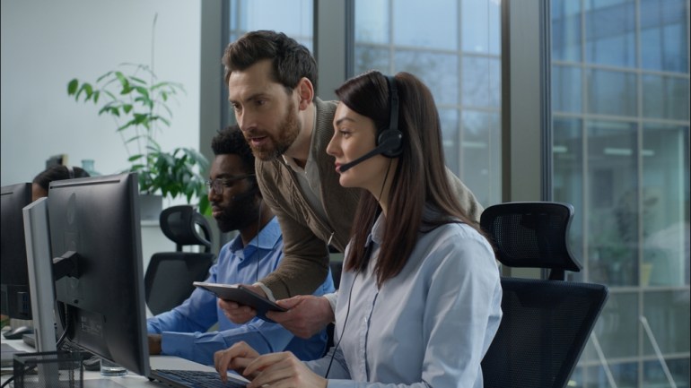 Multi-ethnic inspection call center operators working online consulting customer assistance helpline at office